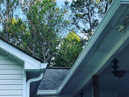 Close up of a clean gutter and downspout protecting painted fascia